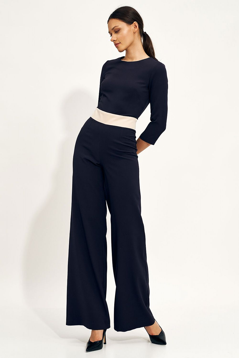 Side view of a stylish one-piece jumpsuit in deep navy, emphasizing the fitted design and flowing wide legs, perfect for upscale occasions.