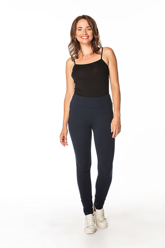 Luxurious cotton knit tracksuit trousers from Tessita, featuring a form-fitting design showcased on a smiling model wearing a black top and white sneakers.