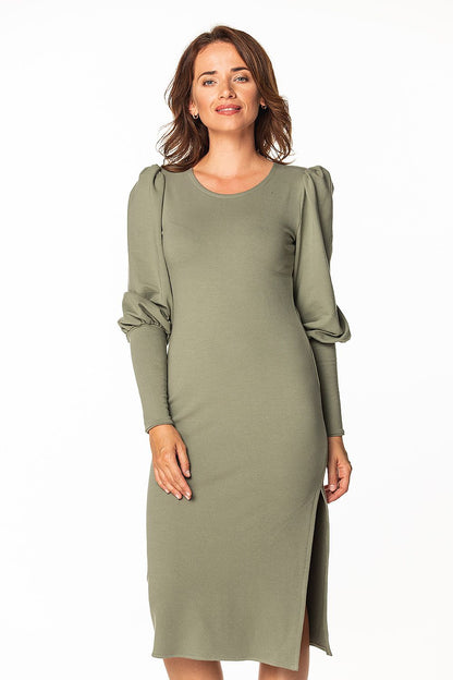 Elegant women's knitted midi dress by Tessita featuring a boat neckline and long buff sleeves, displayed on a model with a graceful expression.