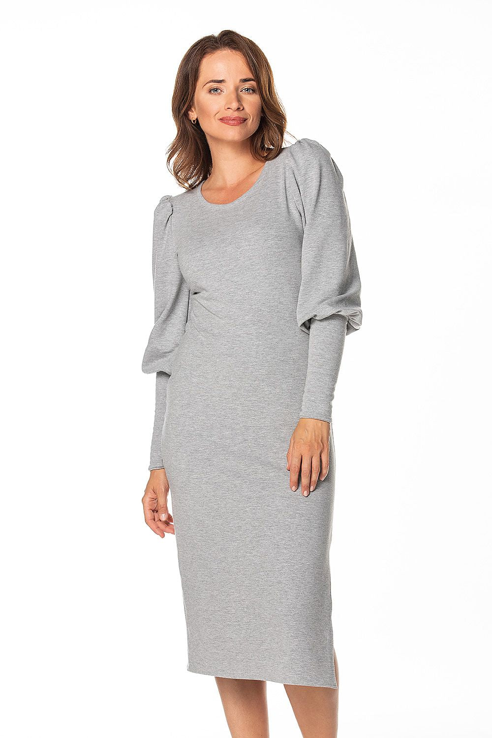 Elegant woman wearing a luxury knitted midi dress with boat neckline and long cuffed sleeves by Tessita in a soft grey tone, showcasing a sophisticated style and comfortable fit.