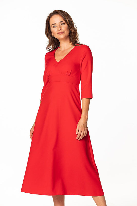 Elegant woman showcasing a luxurious red maxi dress with 3/4 sleeves and pleated bust design by Tessita, perfect for sophisticated occasions.