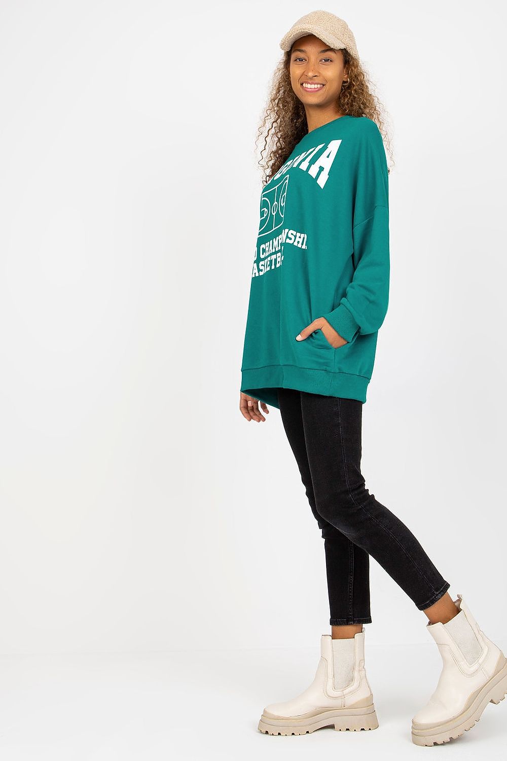 Trendy teal cotton sweatshirt with bold basketball graphics, complemented by black trousers and contemporary ankle boots for a fashionable look.