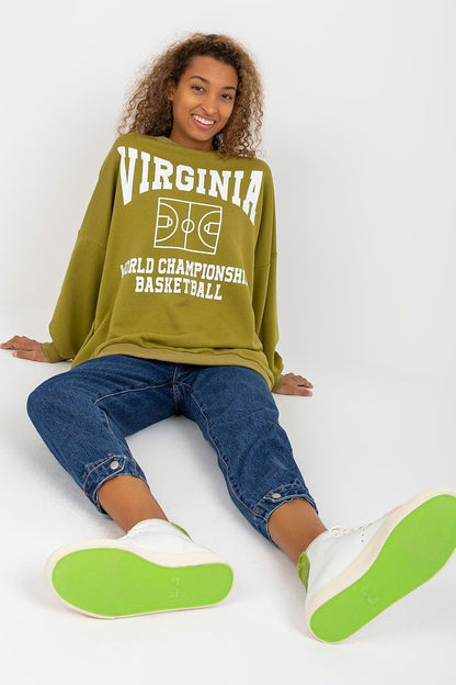 Comfortable and stylish autumn look featuring a relaxed olive green sweatshirt with basketball print, styled with casual denim and trendy footwear.