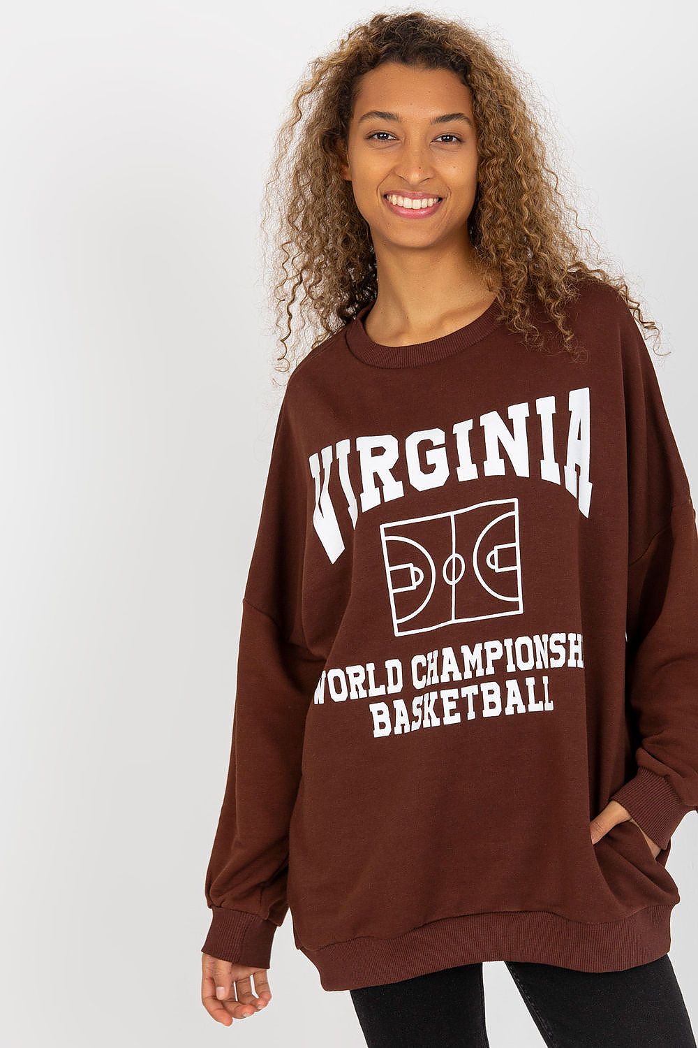 Luxury women's long-sleeved cotton sweatshirt in a rich brown hue, featuring a decorative print of basketball graphics and the word 'VIRGINIA.' Model showcases a comfortable and elegant oversized fit, perfect for casual styling with side pockets.