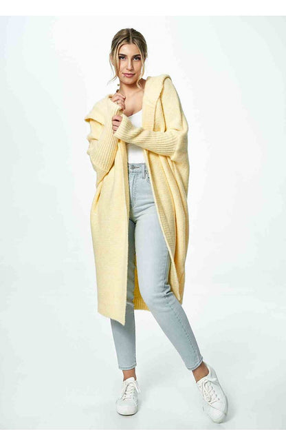 Front view of an elegant yellow Figl cardigan worn over a white top and blue jeans, highlighting its sophisticated style.