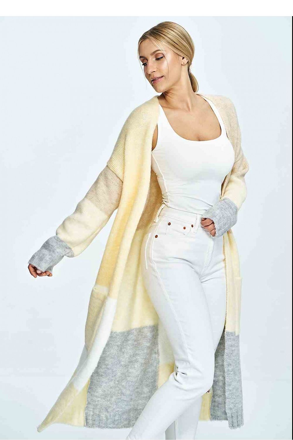 Stylish woman showcasing a luxury cream and grey Figl cardigan, paired with white trousers, exuding elegance with soft wool touch.