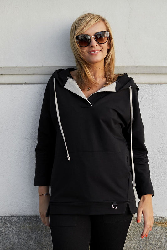 Luxury black hoodie sweatshirt with a stylish hood and cream detailing, model showcasing a sporty-chic look against a minimalist background.