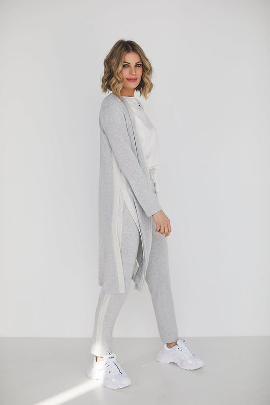 Elegant grey viscose set featuring high waist pants and a loose blouse, modelled by a stylish woman against a minimalist backdrop.