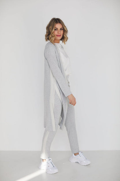 Elegant grey viscose set featuring high waist pants and a loose blouse, modelled by a stylish woman against a minimalist backdrop.