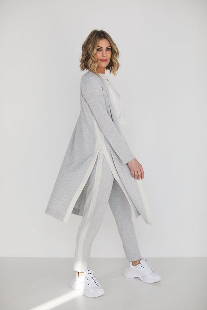 Chic grey high waist pants and blouse ensemble displayed by a fashionable woman, showcasing comfort and sophistication in a sleek environment.