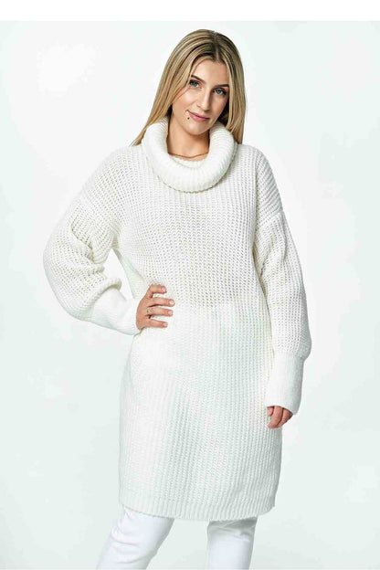 Front view of an elegant long Figl jumper in white, featuring a loose turtleneck and stylish long sleeves, model poses confidently.