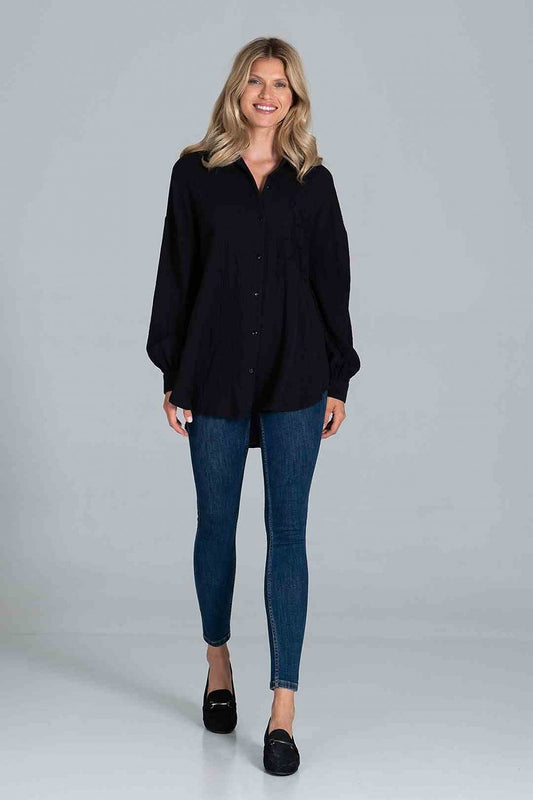 Elegant model showcasing a Figl Classic Oversized Long Sleeve Shirt in black, featuring a decorative pocket and buttoned cuffs, paired with fitted jeans for a chic, stylish look.
