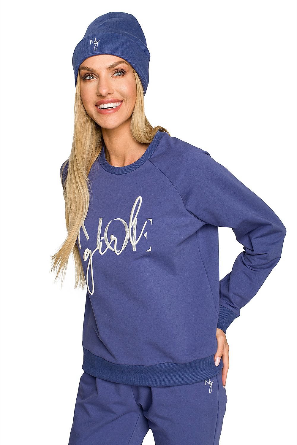Joyful model in a blue ribbed knit beanie and matching sweatshirt, showcasing exquisite embroidery and a relaxed yet elegant vibe for autumn wear.