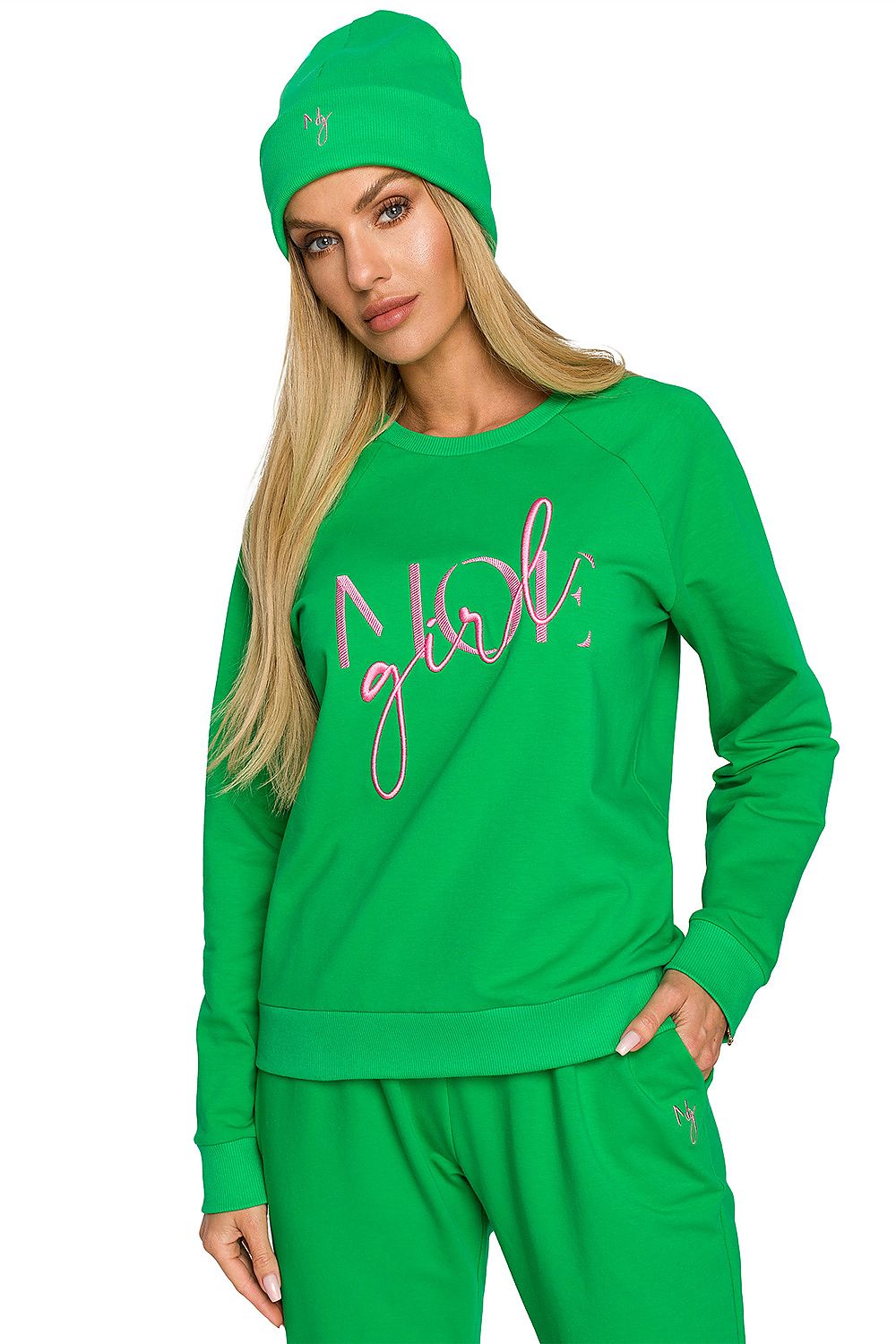 Chic model dressed in a vibrant green outfit featuring a matching ribbed knit cap with elegant embroidery, exuding a fresh and luxurious vibe.