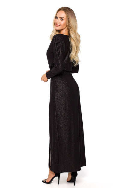 Back view of an elegant black evening dress showcasing long sleeves and a flattering silhouette with a daring leg slit, ideal for formal events.