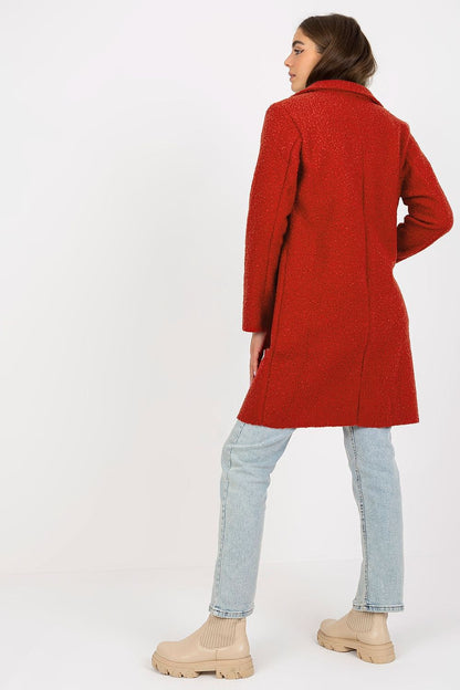 Back view of the Och Bella luxury women's unlined buttoned coat in red, showcasing its sophisticated cut and detail of long sleeves, complemented by casual light blue jeans.
