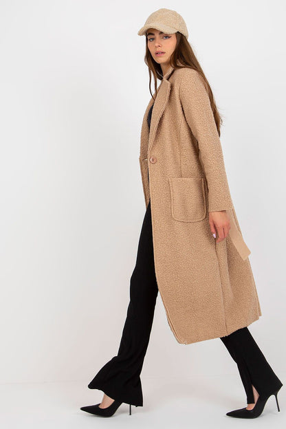 Chic profile view of a luxurious beige women's coat by Och Bella, detailed with a tie belt, patch pockets, and complemented by stylish high heels.