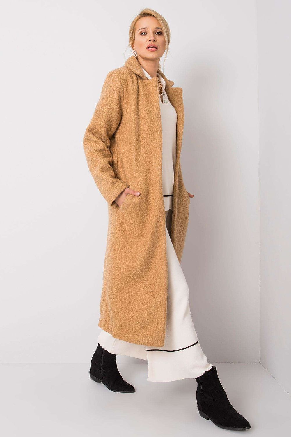 Chic Rue Paris women's long sleeve coat in plush beige fabric, designed with an open front and side pockets, showcased with modern white wide-leg trousers and black boots.