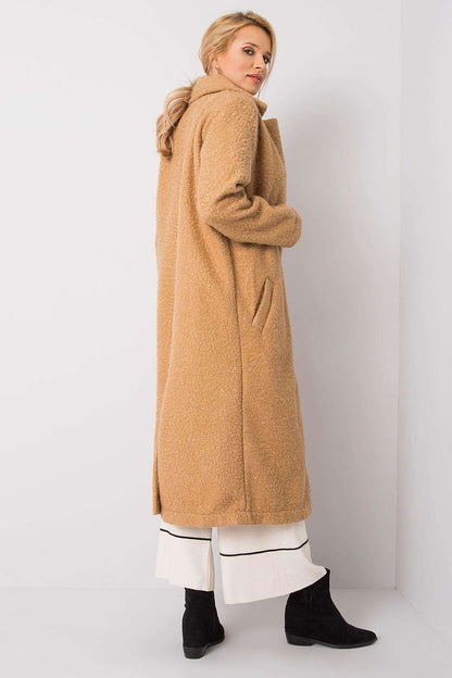 Sophisticated back view of Rue Paris women's long sleeve coat in soft beige, featuring a stylish collar and tailored silhouette, paired effortlessly with black ankle boots.