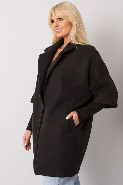 Elegant black women's coat from Rue Paris featuring a loose cut, button closure, and side pockets, worn by a model with blonde hair.