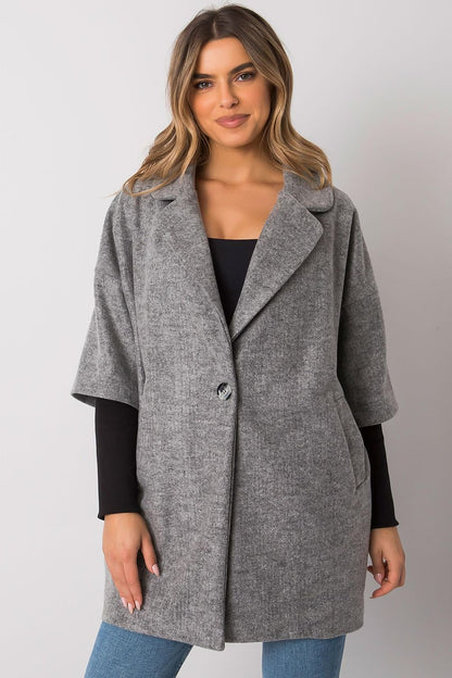 Stylish grey women's coat by Rue Paris, showcasing a relaxed silhouette, button detail, and side pockets, modelled by a young woman.