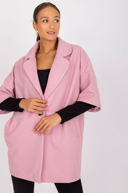 Luxurious pink women's coat from Rue Paris with a loose silhouette and button closure, showcased by a model in a fashionable black ensemble.