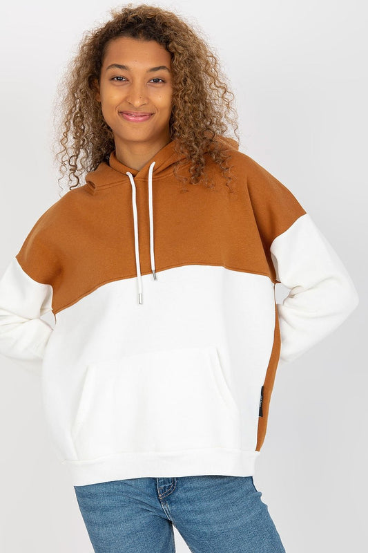 Luxurious women's two-color sweatshirt by Rue Paris, featuring a stylish hood and kangaroo pocket, showcased on a model with curly hair. The sweatshirt's rich brown and elegant white hues exemplify fashionable comfort.