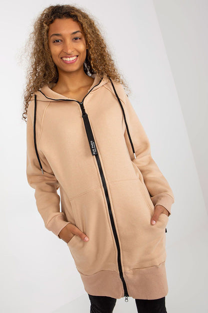 Elegant women's luxury hooded sweatshirt by Rue Paris featuring a zippered front, soft beige fabric, and convenient side pockets, showcasing a relaxed extended cut perfect for stylish comfort.