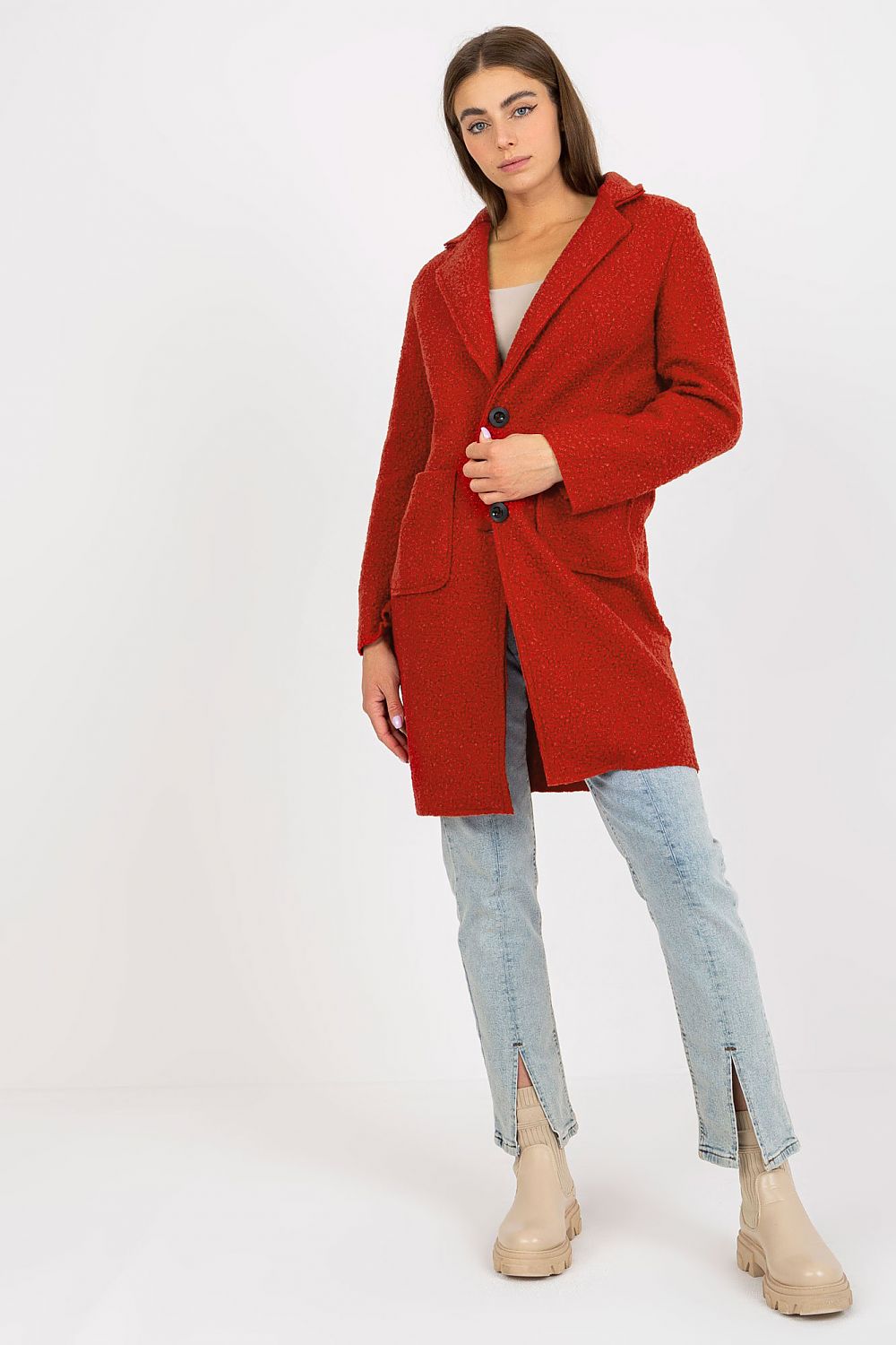 Chic view of the Och Bella luxury women's unlined red coat, buttoned with patch pockets, elegantly paired with light blue jeans and beige ankle boots, perfect for a stylish outing.