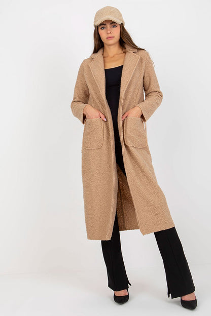 Fashionable front view of a beige long sleeve coat by Och Bella, adorned with patch pockets and a classic tie belt, elegantly styled with high heels.