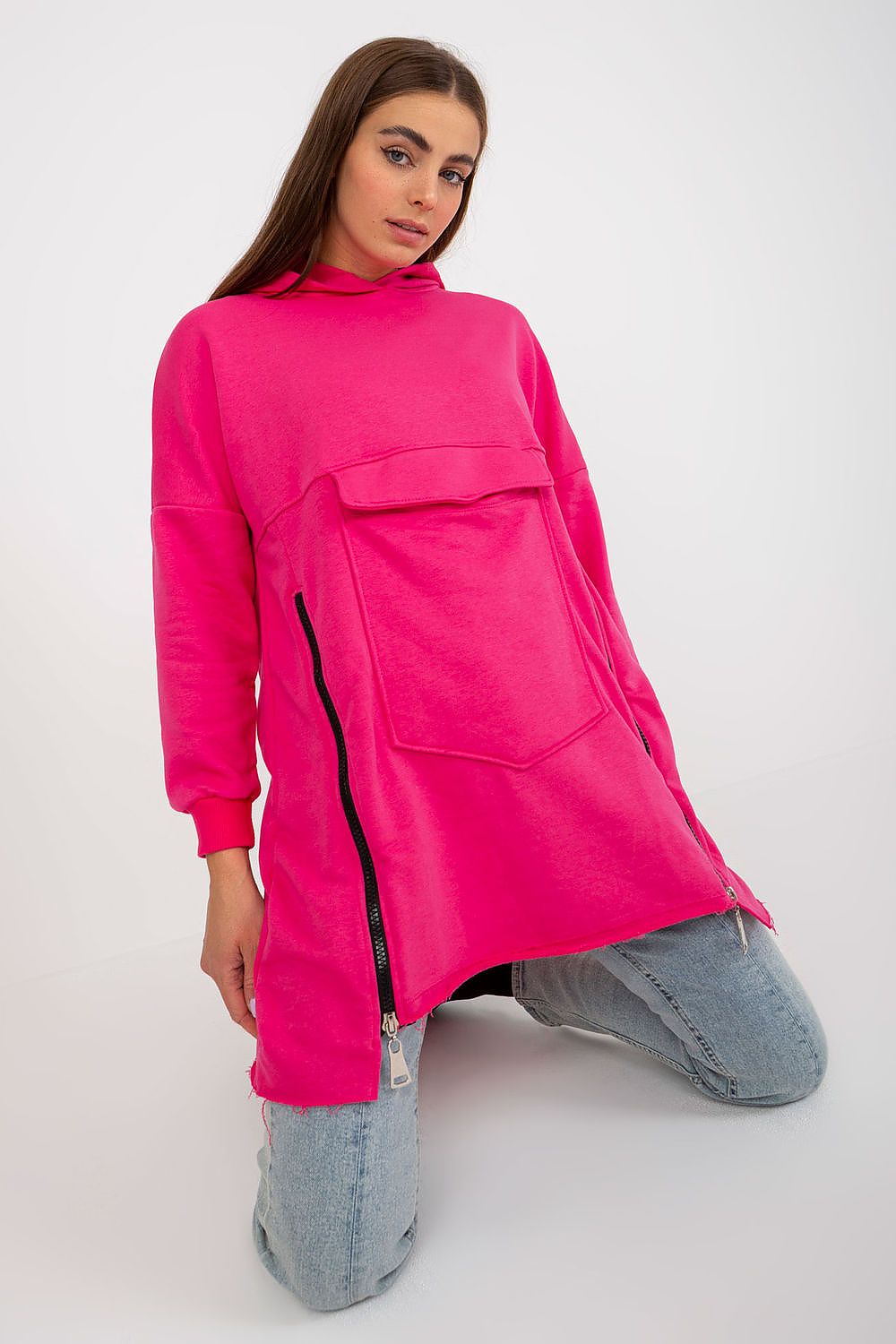Vibrant pink luxury cotton sweatshirt with extended cut, featuring decorative zippers and a roomy front pocket, styled with casual yet chic appeal.