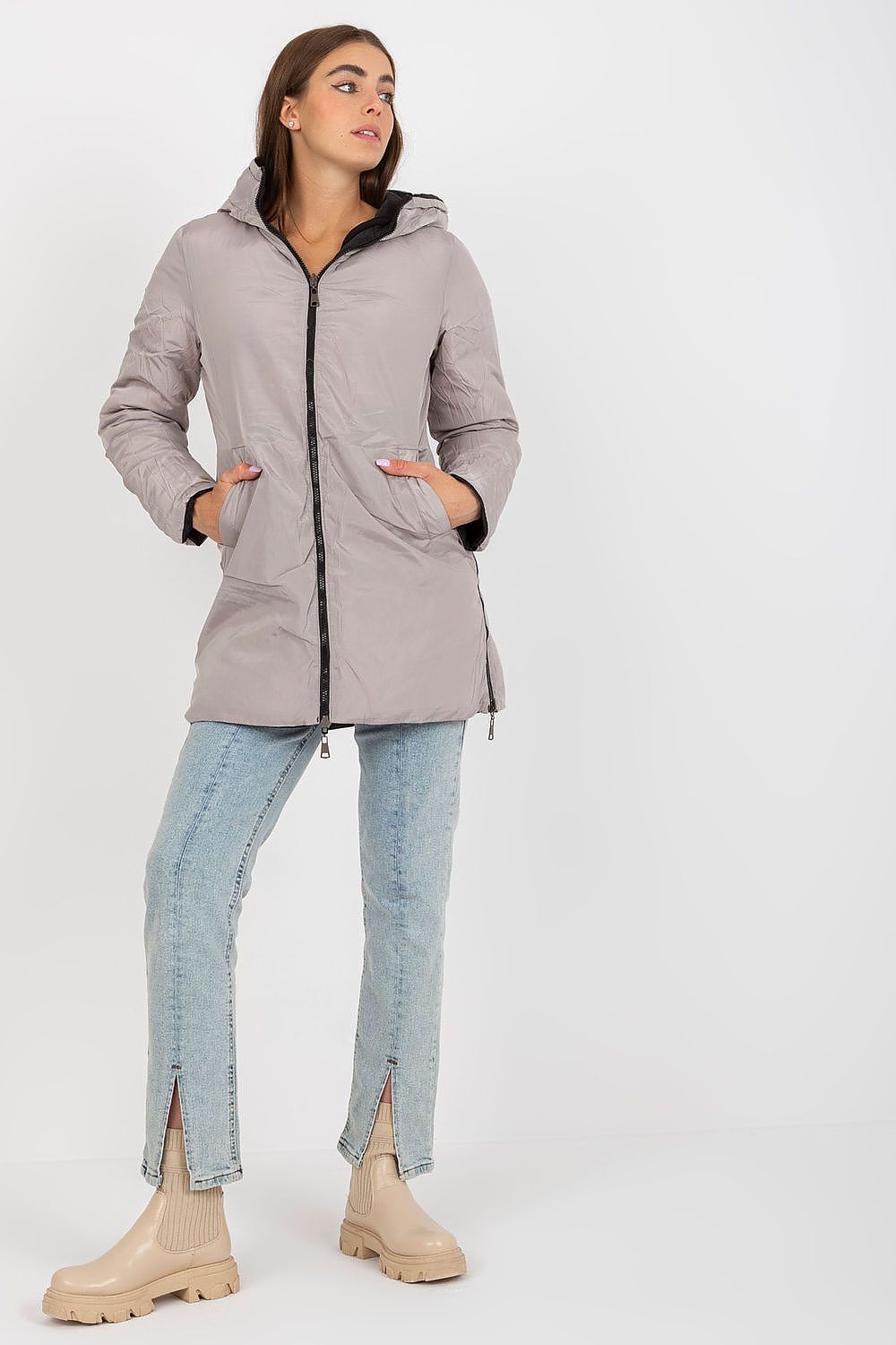 Stylish light grey luxury 100% polyester jacket with zip closure and hood, paired with blue jeans and beige ankle boots, ideal for a sophisticated winter outfit.