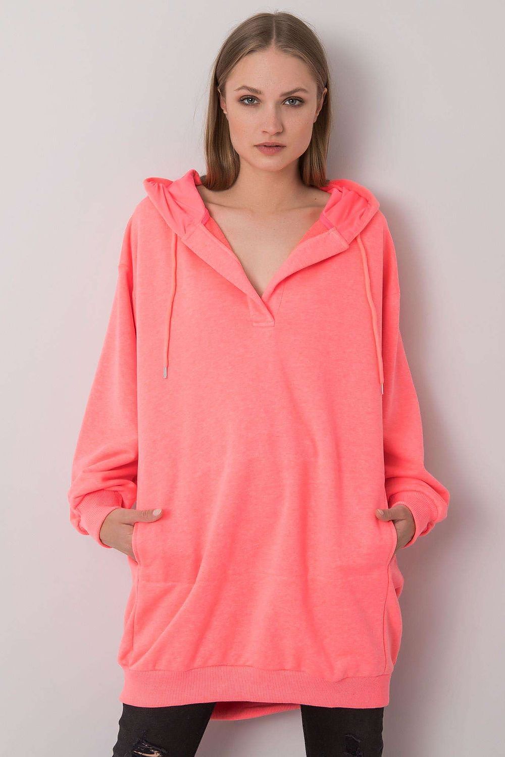 Chic women's extended cut hooded sweatshirt in vibrant neon pink, featuring a stylish kangaroo pocket, perfect for a luxurious casual look.