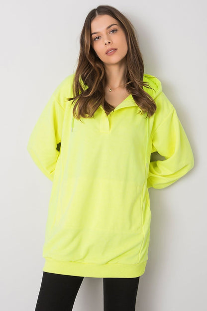 Stylish women's neon yellow hoodie by Ex Moda, showcasing an extended silhouette and kangaroo pocket, perfect for adding a pop of colour to everyday outfits.