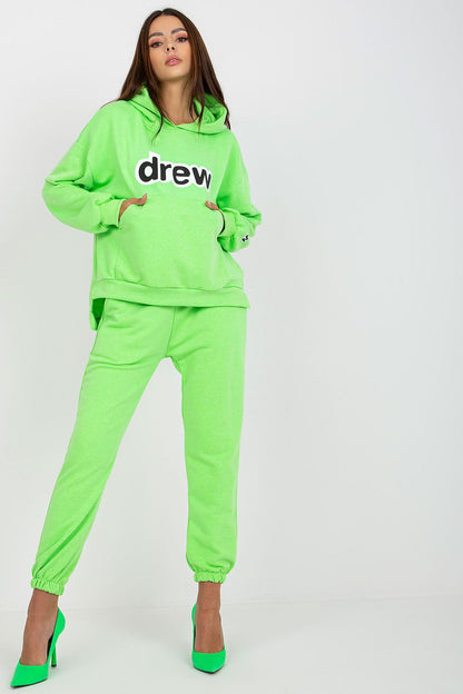Luxurious women's cotton-blend sweatshirt and pants set in vibrant neon green, featuring a hoodie with a kangaroo pocket, styled with high-heeled shoes for an elegant look.