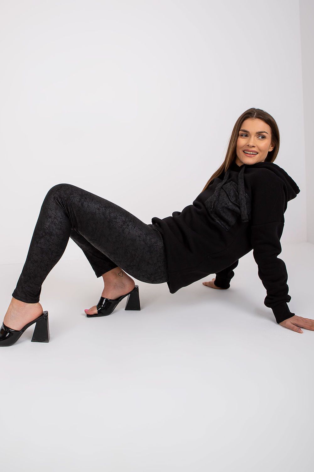 Ex Moda luxury black cotton sweatshirt and leggings set, model reclining elegantly while showcasing the chic design and detailing.