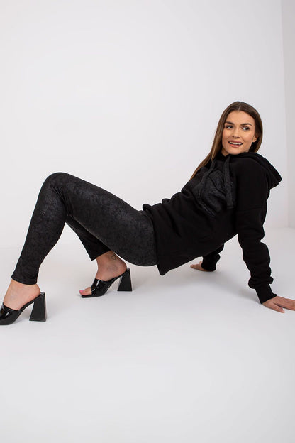 Ex Moda luxury black cotton sweatshirt and leggings set, model reclining elegantly while showcasing the chic design and detailing.