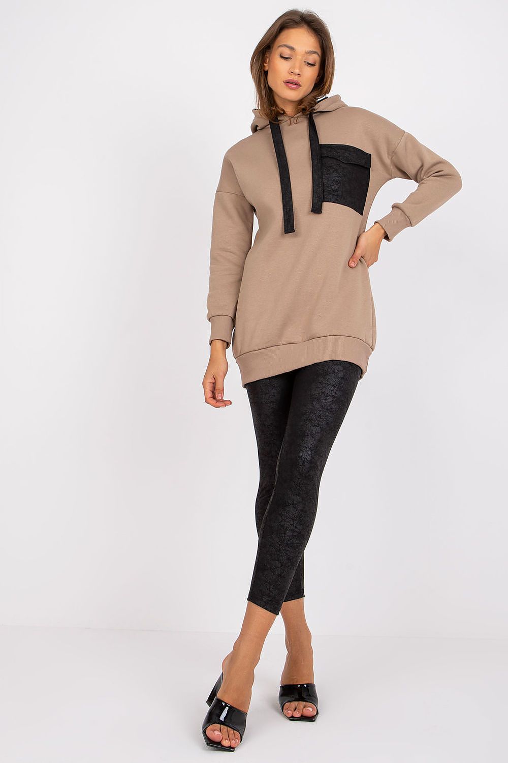 Ex Moda luxurious beige sweatshirt paired with black leggings, model standing gracefully highlighting the fashionable hood and pocket features.