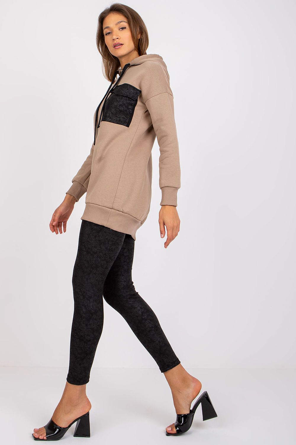 Ex Moda elegant beige sweatshirt and black leggings ensemble, model walking poised to display the contemporary style and sophisticated look.