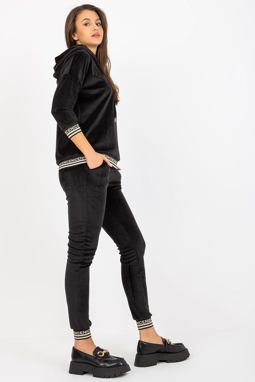 Sophisticated black women's velour set consisting of a hooded sweatshirt and fitted pants, designed with comfort and style in mind, ideal for relaxed yet fashionable outings.
