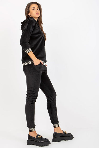 Sophisticated black women's velour set consisting of a hooded sweatshirt and fitted pants, designed with comfort and style in mind, ideal for relaxed yet fashionable outings.
