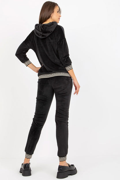 Luxurious women's velour set featuring a black 3/4 sleeve hooded sweatshirt and tailored pants with tie waist, showcasing elegance and comfort.