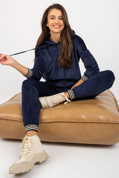 Sophisticated women's velour outfit in navy, highlighting a relaxed hooded sweatshirt and fitted pants, perfect for casual yet stylish outings.