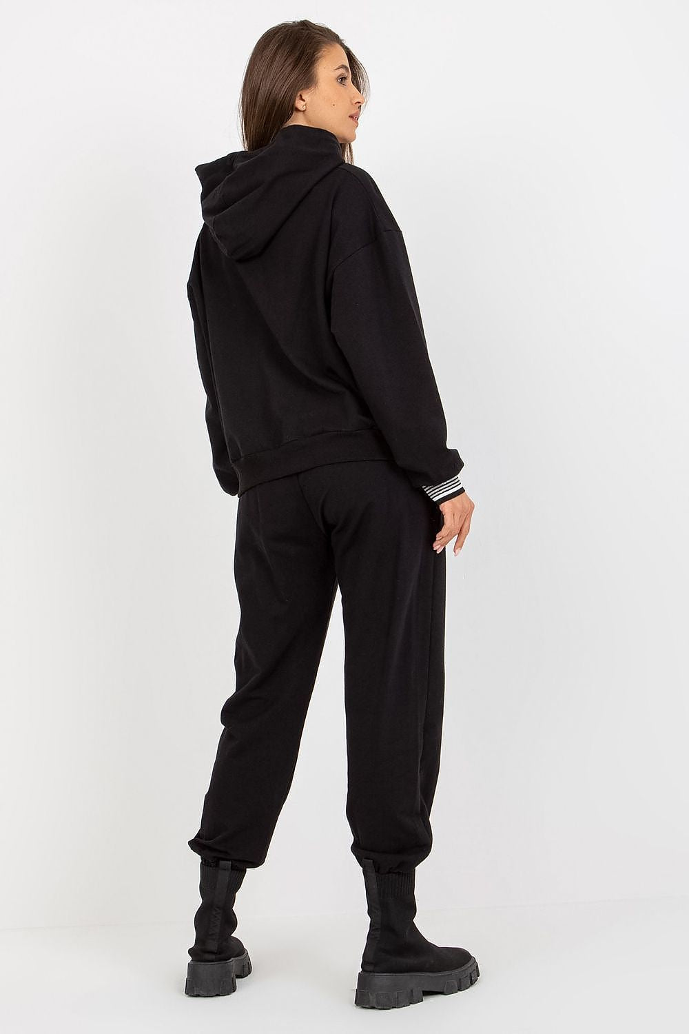 Chic rear view of a woman in a luxurious black sweatshirt and pants set, showcasing the stylish hood and fitted design, perfect for casual elegance.