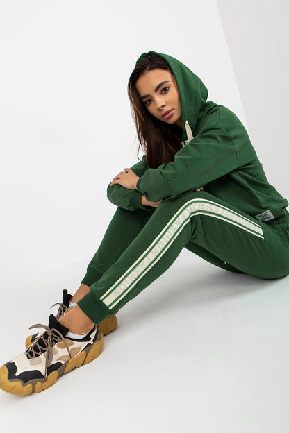Sophisticated model in a deep green cotton-blend hoodie and pants set, seated gracefully, displaying the comfort and style of the outfit.