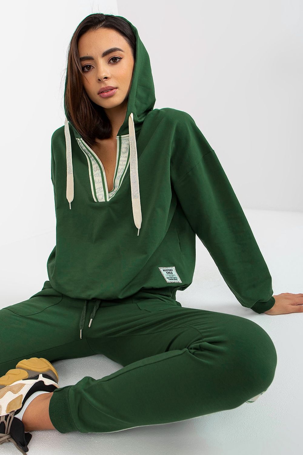 Close-up of a model in a green cotton-blend hoodie with a sporty vibe, highlighting the elegant details and luxurious fabric of the set.