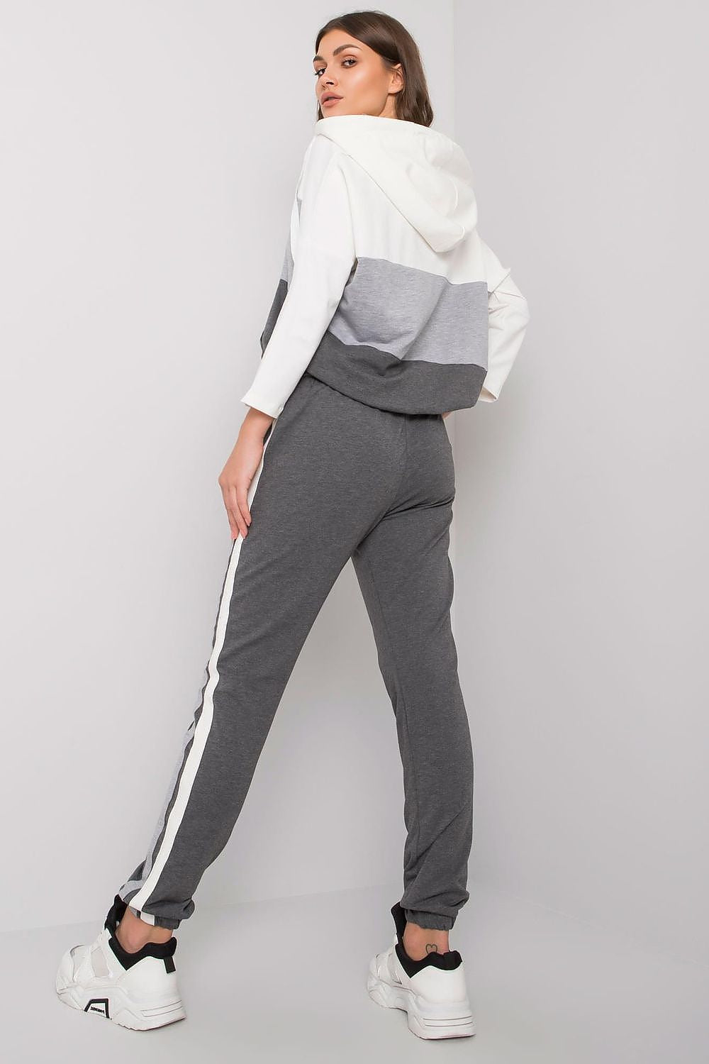 Sophisticated view of a women's grey sweatshirt set showcasing a chic hood and contrasting long pants, ideal for stylish lounging.
