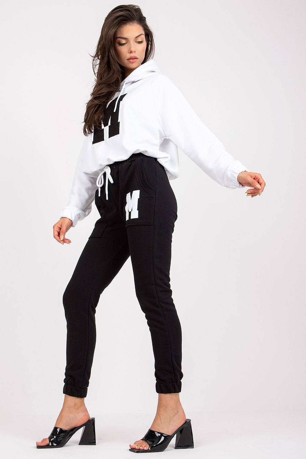 Fashionable model in a luxury black and white sweatshirt and trouser set, showcasing contemporary design with an emphasis on comfort and elegance.