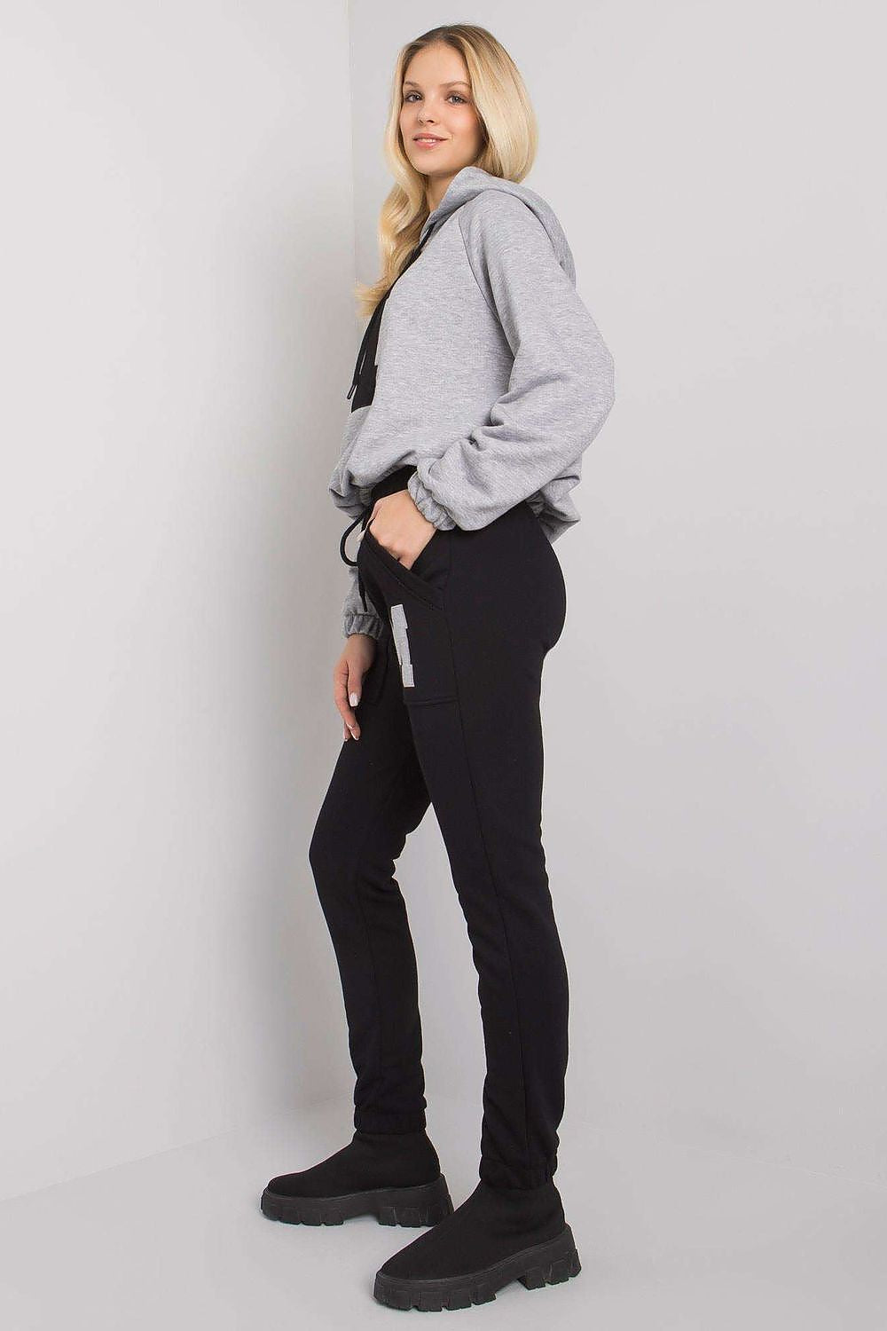Sophisticated view of a women's hoodie and pant set in grey and black, accentuated with a letter 'M' motif, designed for modern leisurewear elegance.