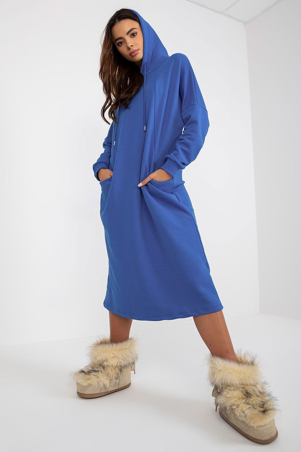 Luxurious loose-fitting cotton spandex sweat dress in vibrant blue with hood, styled with plush fuzzy boots, showcasing side pockets for added elegance.